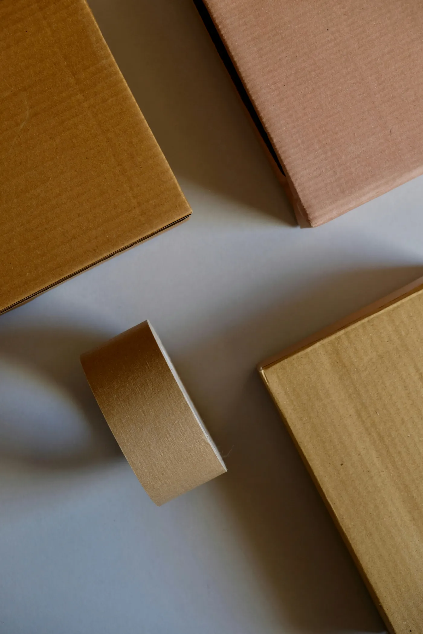 Kraft gift boxes stacked beside a roll of natural paper tape
